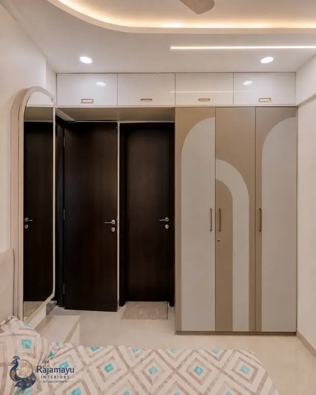 Fitted wardrobes with loft storage by Rajamayu Interiors